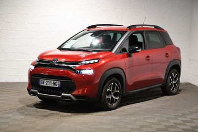 La Citroën rouge est garée dans un garage au sol carrelé