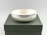 a silver bowl sitting on top of a green box