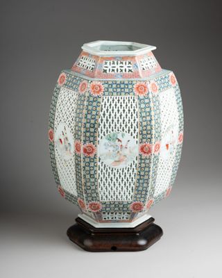 une image représentant un vase posé sur un socle en bois, sur fond gris