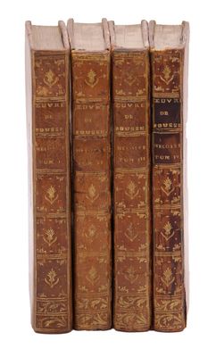 quatre vieux livres sont alignés sur une surface blanche