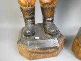 une statue représentant un homme debout au sommet d'un rocher
