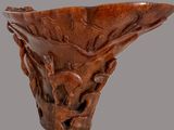 a wooden vase with carvings on it on a gray background
