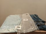 three pairs of jeans sitting on top of a table