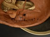 a brown baseball glove with writing on the inside of it