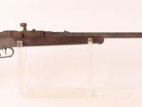 un vieux fusil au canon en bois, posé sur un socle transparent