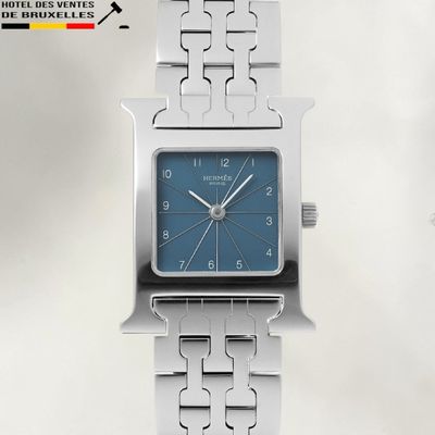 une montre en argent avec un cadran bleu, montée sur un bracelet en argent