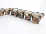 six coffee mugs are lined up in a row on a white surface