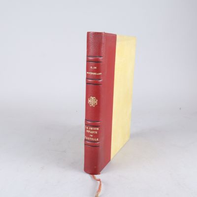 un livre rouge à la couverture jaune posé sur une surface blanche