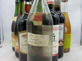 Des bouteilles de vin sont alignées sur une table devant un fond blanc.