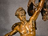 a statue of a man holding a shoe in his hand