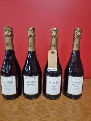 quatre bouteilles de vin sont alignées sur une table en bois