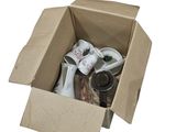 une boîte en carton remplie d'objets divers posée sur une surface blanche