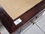 une table en bois avec un tiroir en dessous, posée sur un sol carrelé