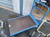 un caddie bleu et un chariot bleu posé par terre