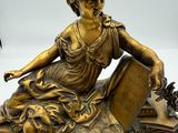a statue of a woman sitting on top of a clock