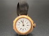 une montre en or avec des chiffres romains sur le cadran