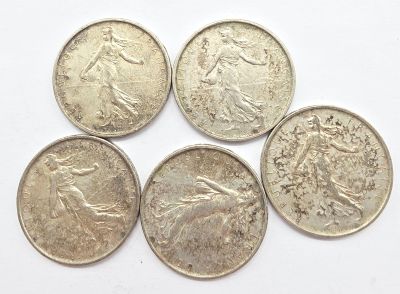 quatre pièces d'argent empilées les unes sur les autres sur une surface blanche