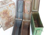 several old metal containers sitting next to each other on a white surface