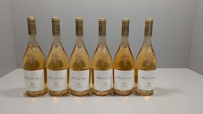 six bouteilles de vin sont alignées sur une table