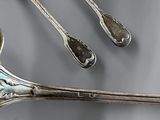 three spoons and two spoons sitting on a table