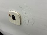 a close up of a white car with a hole in the door