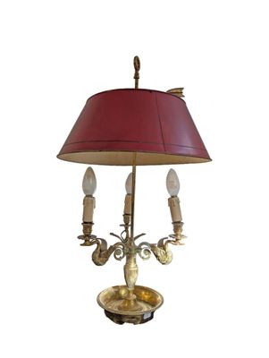 brass table lamp with a red shade on a white background