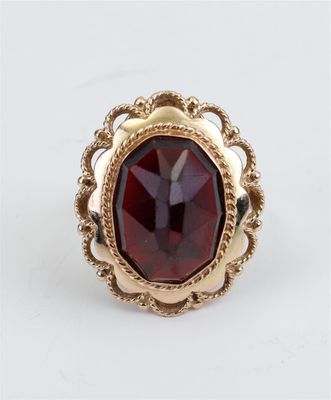 Gros plan sur une bague contenant une pierre rouge