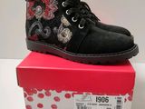 the children ' s black boots are on top of a pink box