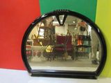 un miroir posé sur une table devant un mur coloré