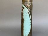 an old brass vase with a green patt on it