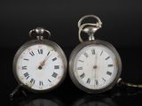 une paire de montres de poche anciennes, avec des chiffres romains se détachant sur un fond noir