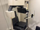 une photo d'une salle de consultation avec une chaise et un écran