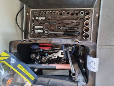 de nombreux outils dans une boîte à outils posée par terre