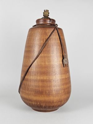 une image représentant un vase en bois entouré d'une lanière