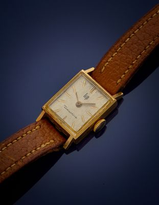 une image d'une montre en or avec un bracelet en cuir marron