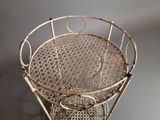 a metal chair that has a basket on top of it