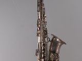 a close up of a saxophone on a string with a gray background