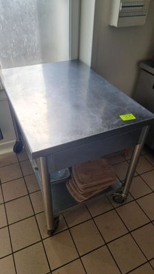une table en acier inoxydable dans une cuisine, sur laquelle est collé un autocollant jaune
