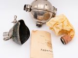 a silver teapot and a book on a table