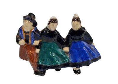 trois figurines représentant des personnes assises sur un banc