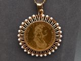 a close up of a gold coin with pearls on a necklace
