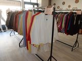a lot of shirts hanging on a rack in a store