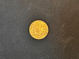 une pièce d'or posée sur une surface noire