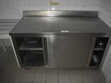 a stainless steel counter in a kitchen with white tiles