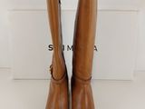 a pair of brown boots sitting on top of a white box