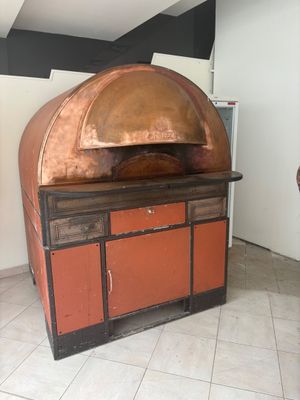 a large copper oven in the middle of a room