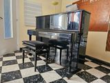 a piano and stool in a room with a checkered floor