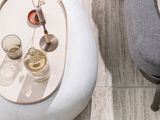 a white table with two glasses of wine and a vase on it