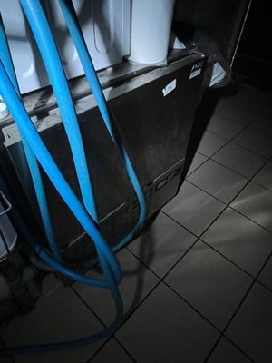 un tuyau bleu raccordé à un réfrigérateur dans une pièce sombre