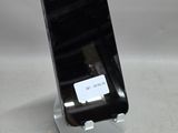 un téléphone portable posé sur un support sur une table